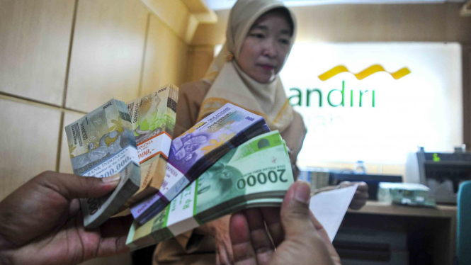 Petugas salah satu bank melayani warga melakukan penukaran uang pecahan