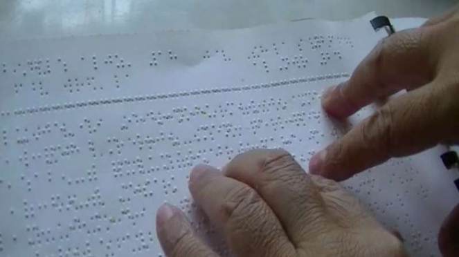 Penyandang tunanetra membaca Alquran Braille