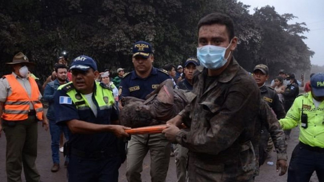 Rescue workers carry a wounded man in El Rodeo, near the Fuego volcano - EPA