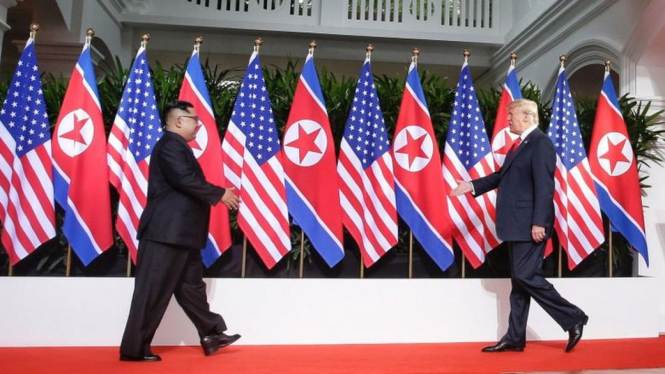 Kim Jong Un dan Donald Trump berjabat tangan selama beberapa detik untuk memulai pertemuan yang dianggap bersejarah itu. - Getty Images