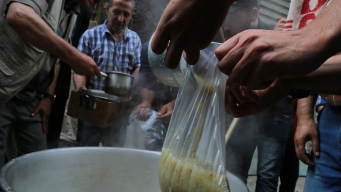 Warga Palestina di Gaza mengambil sup gratis untuk berbuka puasa. - Getty Images