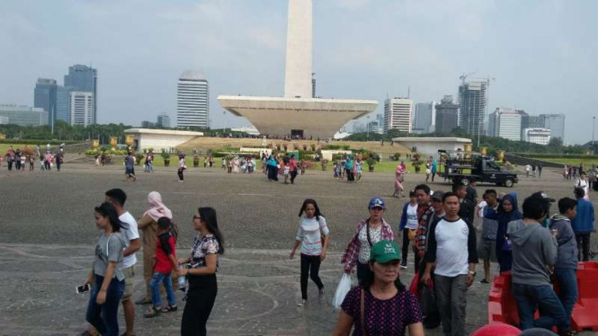 Warga Jakarta menikmati hari libur di Monas pada hari kedua Lebaran 2018.