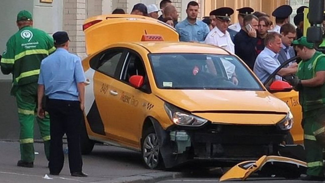 Taksi warna kuning itu berhenti setelah menabrak tanda jalan di kota Moskow. - Reuters