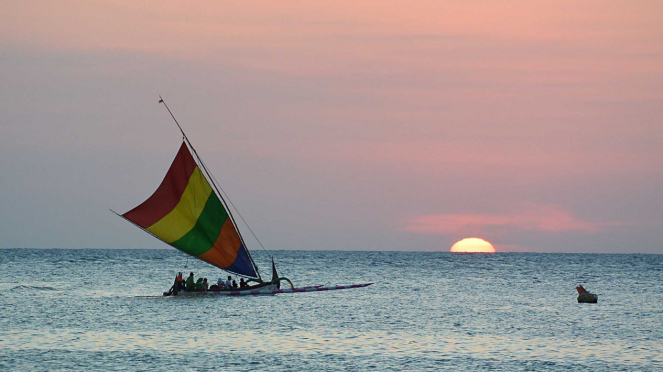 Pengunjung menaiki perahu layar di Pantai Pasir Putih Situbondo, Jawa Timur