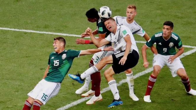 Bintang Jerman Thomas Mueller saat berebut bola dengan pemain Meksiko