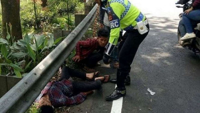 Polisi memeriksa dua pemuda yang terkapar di Jalan Raya Puncak.
