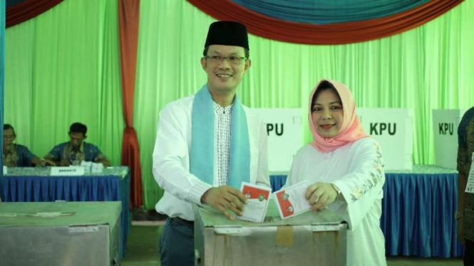 Calon petahana wali kota Palembang, Harnojoyo, menggunakan hak suaranya di TPS 08, Kelurahan Karya Jaya, Kecamatan Gandus Palembang, Sumatra Selatan, pada Rabu pagi, 27 Juni 2018.