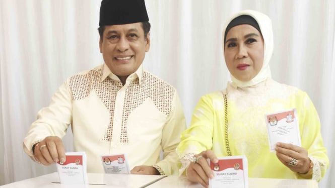 Calon Gubernur Sulsel Nurdin Halid (kiri) dan istri Andi Nurbani, memasukkan surat suara ke dalam kotak saat  pemilihan Gubernur-Wakil Gubernur Sulsel dan Walikota-Wakil Walikota Makassar