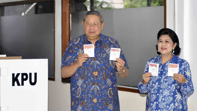 Presiden ke-6 RI sekaligus Ketua Umum Partai Demokrat Susilo Bambang Yudhoyono (kiri) bersama istri Ani Yudhoyono, menunjukkan surat suara saat menggunakan hak pilih di Pilkada Serentak 2018