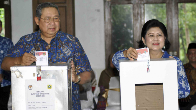 Presiden ke-6 RI sekaligus Ketua Umum Partai Demokrat Susilo Bambang Yudhoyono (kiri) bersama istri Ani Yudhoyono, memasukkan surat suara ke dalam kotak saat menggunakan hak pilih di Pilkada Serentak 2018