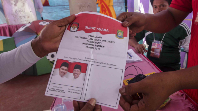 Warga menunjukkan surat suara saat menggunakan hak suara pada Pilkada Kota Tangerang 2018