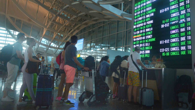 Penumpang mencari informasi jadwal penerbangan setelah terjadinya aktivitas vulkanik Gunung Agung di Bandara Ngurah Rai, Bali, Jumat, 29 Juni 2018