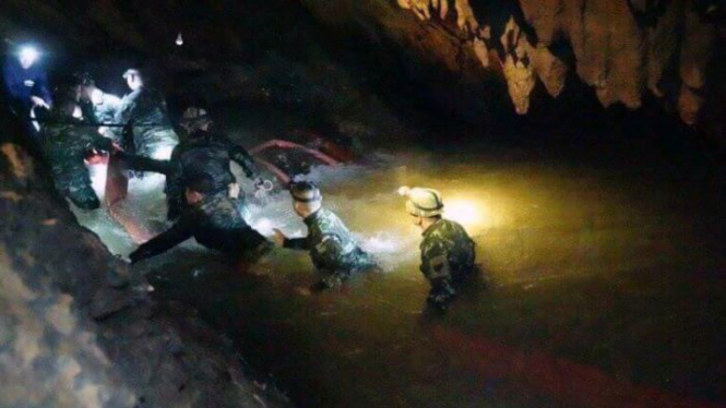 Foto yang dikeluarkan Tham Luang Rescue Operation Centre, tim pencari berjalan memasuki kompleks gua di mana 12 anak dan pelatih sepakbola mereka hilang selama sembilan hari di Mae Sai, Provinsi Chiang Rai, Thailand, 2 Juli 2018.