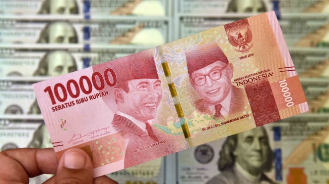 Ein Devisenbeamter prüft in Jakarta Rupiah- und US-Dollar-Banknoten