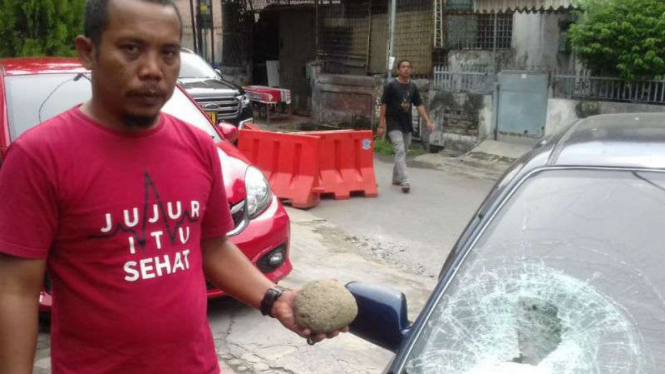 Muhammad Arief Tampubolon, seorang jurnalis sebuah media online, korban teror oleh orang tak dikenal saat memperlihatkan mobilnya yang rusak di Medan, Sumatra Utara, pada Senin, 9 Juli 2018.