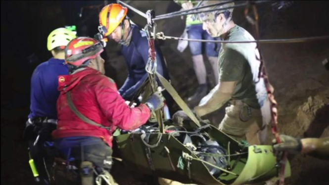 This undated photo from video released via the Thai NavySEAL Facebook Page on Wednesday, July 11, 2018, shows rescuers hold an evacuated boy inside the Tham Luang Nang Non cave in Mae Sai, Chiang Rai province, in northern Thailand.
