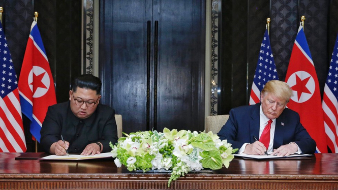 Kim Jong-un (kiri) dan Donald Trump menandatangani kesepakatan dalam pertemuan bersejarah di Singapura. - Getty Images