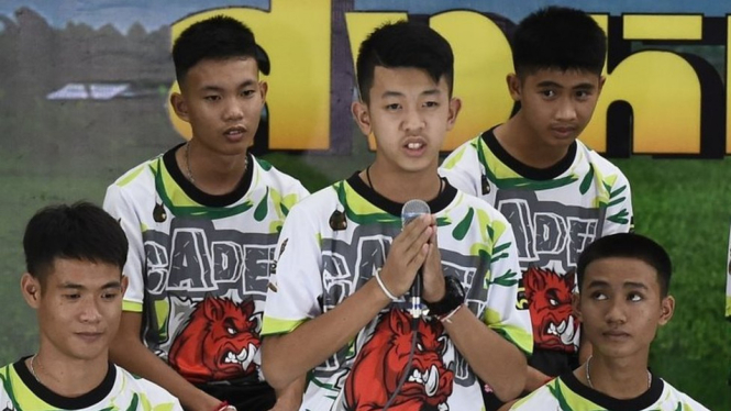 Pornchai Khamluang (tengah), salah satu dari 12 anak laki-laki yang diselamatkan, berbicara di konperensi pers di Chiang Rai (18 Juli). - AFP Getty