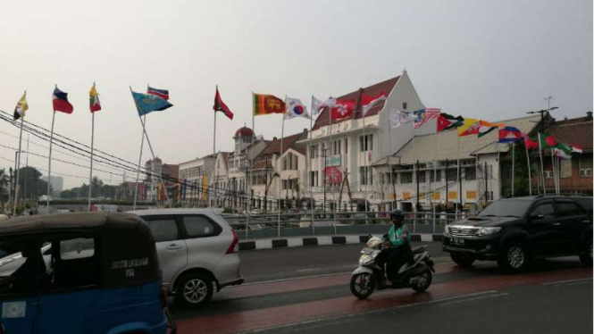 Bendera-bendera negara Asian Games dipasang dengan bilah bambu.