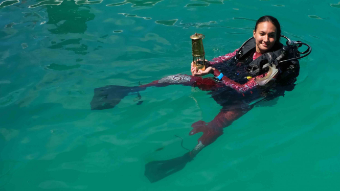 Artis Nadine Chandrawinata berenang sambil membawa obor Asian Games 2018 di perairan Raja Ampat, Papua Barat