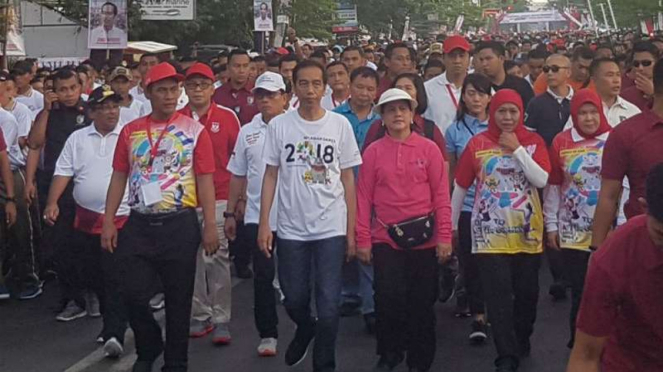 Presiden Joko Widodo dan ibu negara Iriana mengikuti kegiatan jalan santai bersama warga di Makassar, Sulawesi Selatan, pada Minggu pagi, 29 Juli 2018.