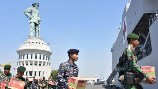 Prajurit TNI mengangkut logistik bantuan untuk korban gempabumi di Lombok, Nusa Tenggara Barat, ke dalam kapal perang di Dermaga Ujung Surabaya pada Senin, 6 Agustus 2018.