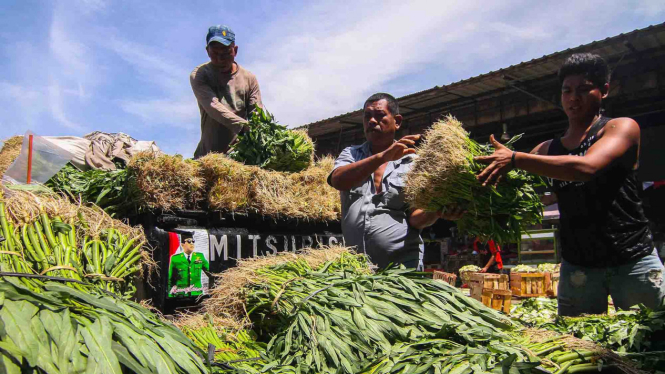 Pekerja membongkar muat sayuran di Pasar Induk Kramat Jati, Jakarta