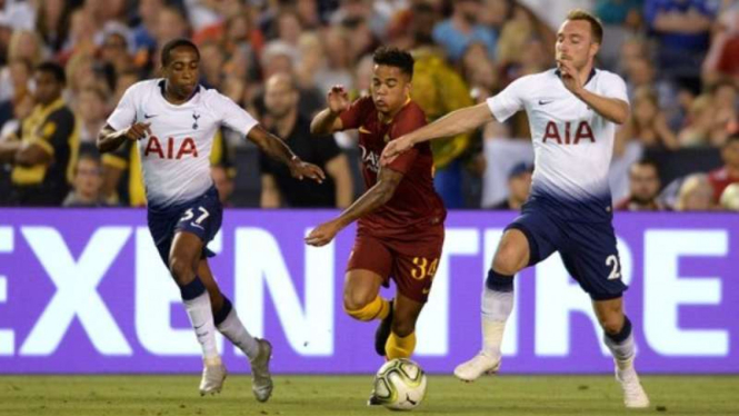 Striker AS Roma, Justin Kluivert (tengah) diapit pemain Tottenham Hotspur.