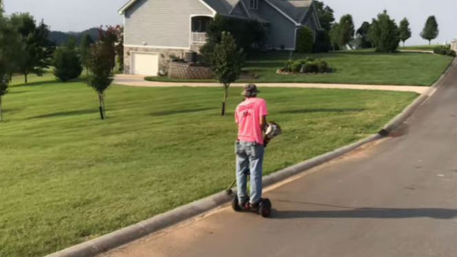 Seorang pria membersihkan rumput liar.