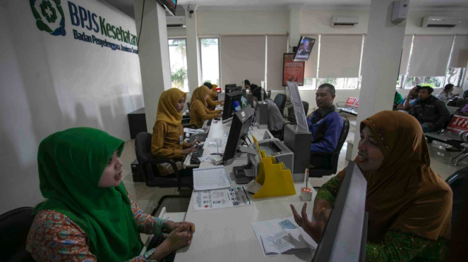 Petugas melayani warga di kantor Badan Penyelanggara Jaminan Sosial (BPJS) Kesehatan