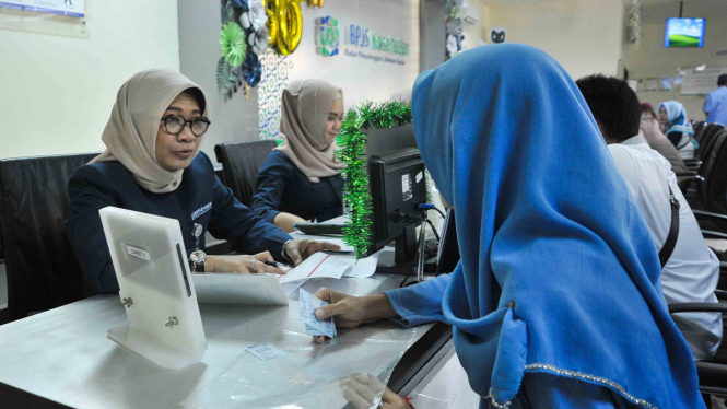Direktur Sumber Daya Manusia (SDM) dan Umum Badan Penyelenggara Jaminan Sosial (BPJS) Kesehatan Mira Anggraini melayani peserta Jaminan Kesehatan - Kartu Indonesia Sehat (JKN-KIS) di Kantor Cabang Palembang, Sumatera Selatan