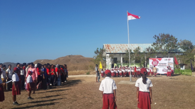 Anak-anak Indonesia mengikuti upacara bendera.