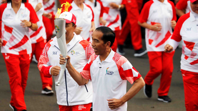 Presiden Joko Widodo membawa obor Asian Games 2018