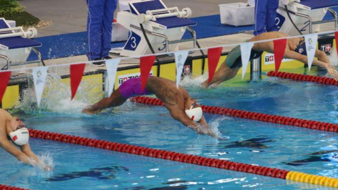 Aksi perenang Indonesia, I Gede Siman Sudartawa (tengah) di GBK Aquatic Stadium.