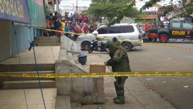 Personel Penjinak Bahan Peledak dan Bom Polda Jawa Timur memeriksa kardus mencurigakan yang ditemukan warga di depan sebuah toko emas di Pasar Karangploso, Malang, pada Jumat, 31 Agustus 2018.