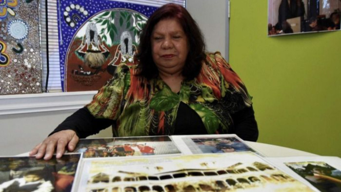 Lyn Austin, salah satu generasi yang dicuri duduk di meja melihat foto keluarga di Melbourne, September 2018.