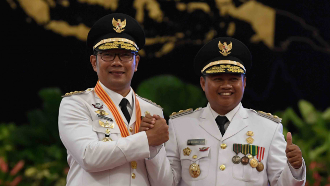 Gubernur Jawa Barat Ridwan Kamil (kiri) bersama Wakil Gubernur Uu Ruzhanul Ulum (kanan) melakukan salam komando usai pelantikan di Istana Negara, Jakarta