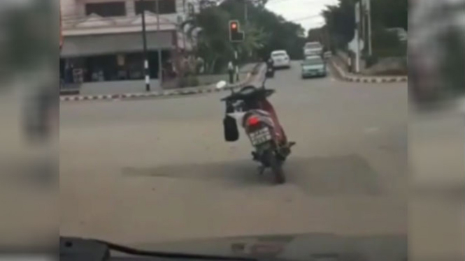 Pria tinggalkan motor di lampu merah.