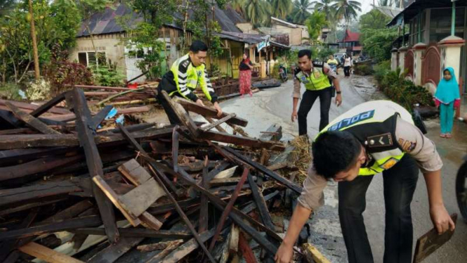 Aparat bersama warga membersihkan permukiman setelah diterjang banjir bandang Kabupaten Solok, Sumatera Barat, pada Jumat, 7 September 2018.