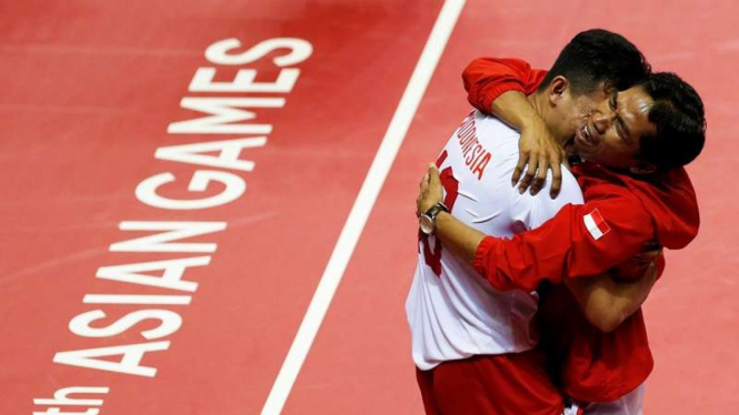 Pelatih sepak takraw Indonesia Asry Syam (kanan) rayakan medali emas Asian Games