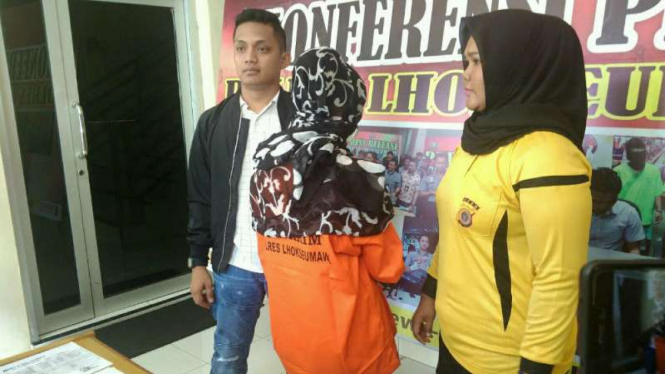 Dua petugas polisi memperlihatkan seorang wanita tersangka pelaku perdagangan manusia atau human trafficking lintas negara yang ditangkap di Lhokseumawe, Aceh, pada Jumat, 7 September 2018.