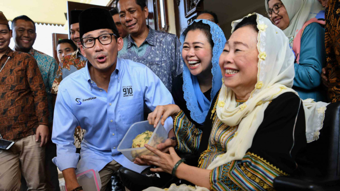 Bakal calon Wakil Presiden Sandiaga Uno (kiri) menunjukkan tempe yang diberikan oleh Ibu Sinta Nuriyah Wahid (kanan) disaksikan putri kedua Abdurrahman Wahid, Yenny Wahid (tengah) saat berkunjung ke Ciganjur, Jakarta