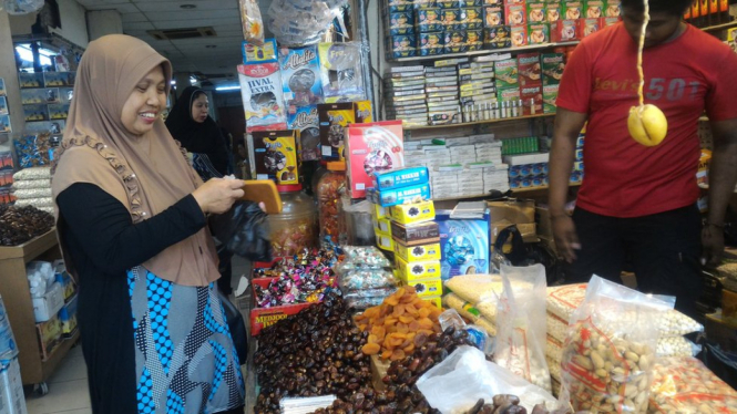 Seorang pengunjung membeli sejumlah oleh-oleh haji di Tanah Abang, Jakarta Pusat. - BBC News Indonesia