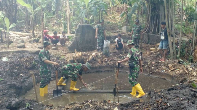 Personel TNI membersihkan mata air di Depok, Jawa Barat.