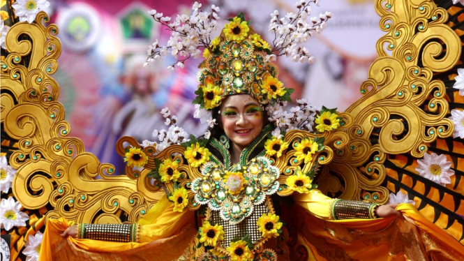 Seorang peseta memamerkan busana dalam Fashion Flower Carnival di Malang, Jawa Timur, Minggu (16/9). Kegiatan tahunan tersebut diadakan untuk memberi wadah kepada para desainer muda untuk berkompetisi dan berkreasi menciptakan busana unik. - Antara/ARI BO
