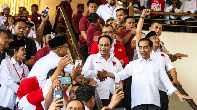 Presiden Joko Widodo (kanan) bersama Ketua Umum DPP Projo Budi Arie Setiadi (kedua kanan) menyapa relawan ketika menghadiri Rakernas IV Projo di Jakarta