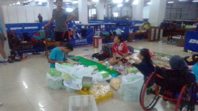Atlet tenis meja Indonesia makan nasi kotak di pusat latihan Solo.