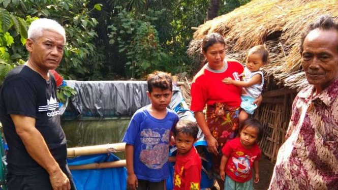 Pengungsi korban gempa di Lombok menampung air dengan terpal untuk dikonsumsi sehari-hari.