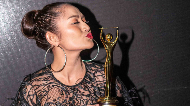 Penyanyi Siti Badriah berpose memegang piala penghargaan pada Malam Anugerah Musik Indonesia (AMI) 2018 di Jakarta