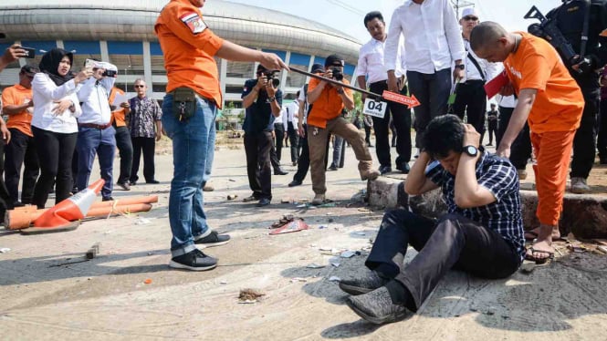 Seorang tersangka memperagakan tindakannya saat rekonstruksi pengeroyokan yang dilakukan oleh oknum bobotoh terhadap seorang suporter Persija, Haringga Sirla, di Stadion Gelora Bandung Lautan Api (GBLA), Bandung, Jawa Barat